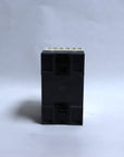 A small black plastic electrical component or terminal block with a light beige connector strip on top, photographed upright against a plain light gray background.